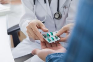 Medical professional giving a patient some tablets