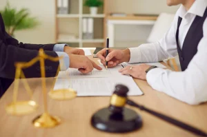 A No Win No Fee solicitor and doctor discussing NHS injury at work compensation at a desk with scales and a gavel. 