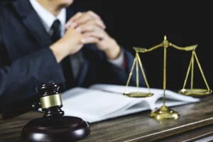 A solicitor at a desk with an open law book, scales and a gavel.