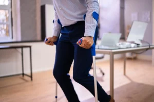 An office worker walking on crutches after a leg injury.